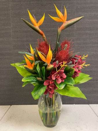 Tropisk blomsteroppsats i vase