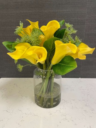 Gul blomsteroppsats i glassvase